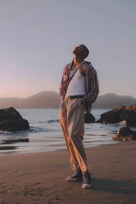 a man standing on top of a beach next to the ocean, tupac, profile image