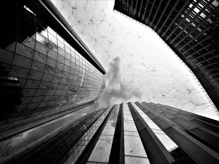 a black and white photo of tall buildings, inspired by Richard Wilson, ((fish eye)), architecture art, cloud day, hong kong buildings