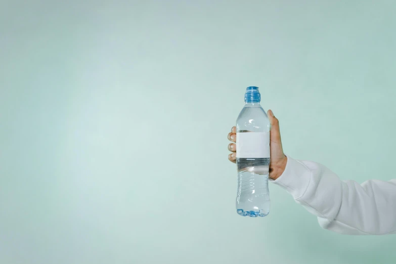 a person holding a bottle of water in their hand, listing image, background image, ignant, no - text no - logo