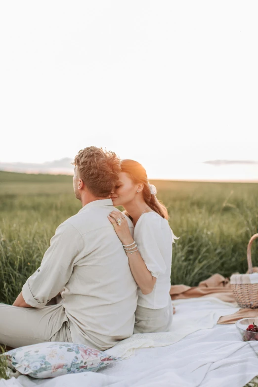 a man and woman sitting on a blanket in a field, pexels contest winner, romanticism, fine dining, white, morning glow, embracing