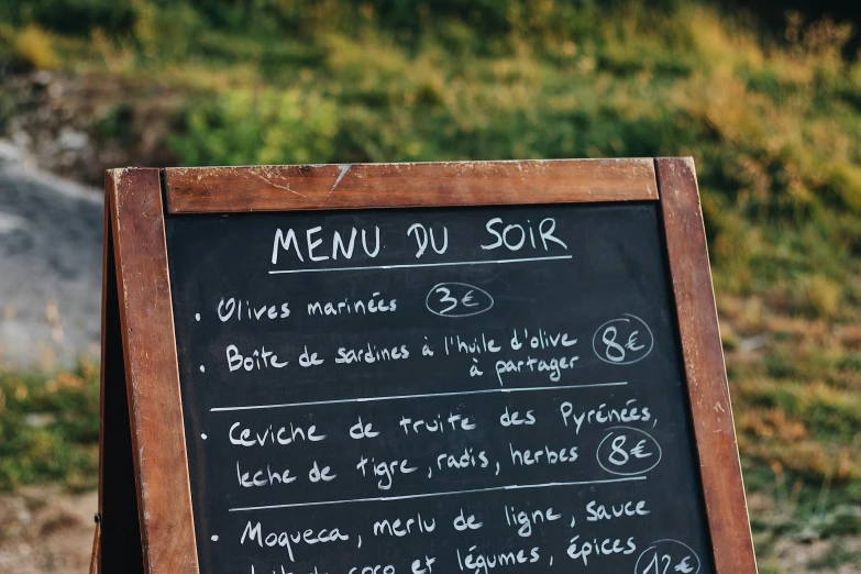a chalk board with a menu written on it, a screenshot, by Pierre Mion, pexels, les nabis, mountainside, up-close, st cirq lapopie, thumbnail