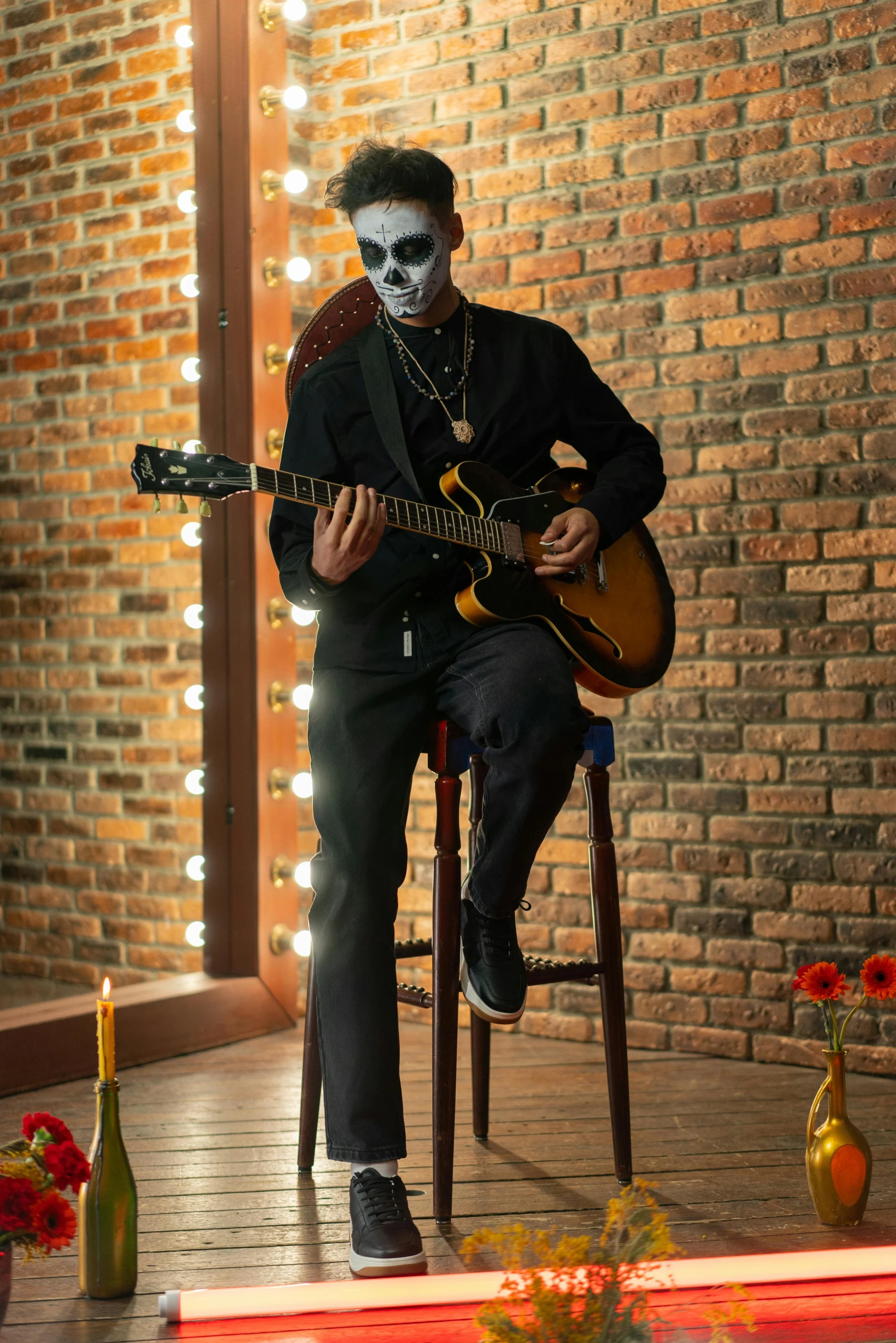 a man sitting on a chair playing a guitar, inspired by James Bolivar Manson, skull face paint, epk, full-body, profile image