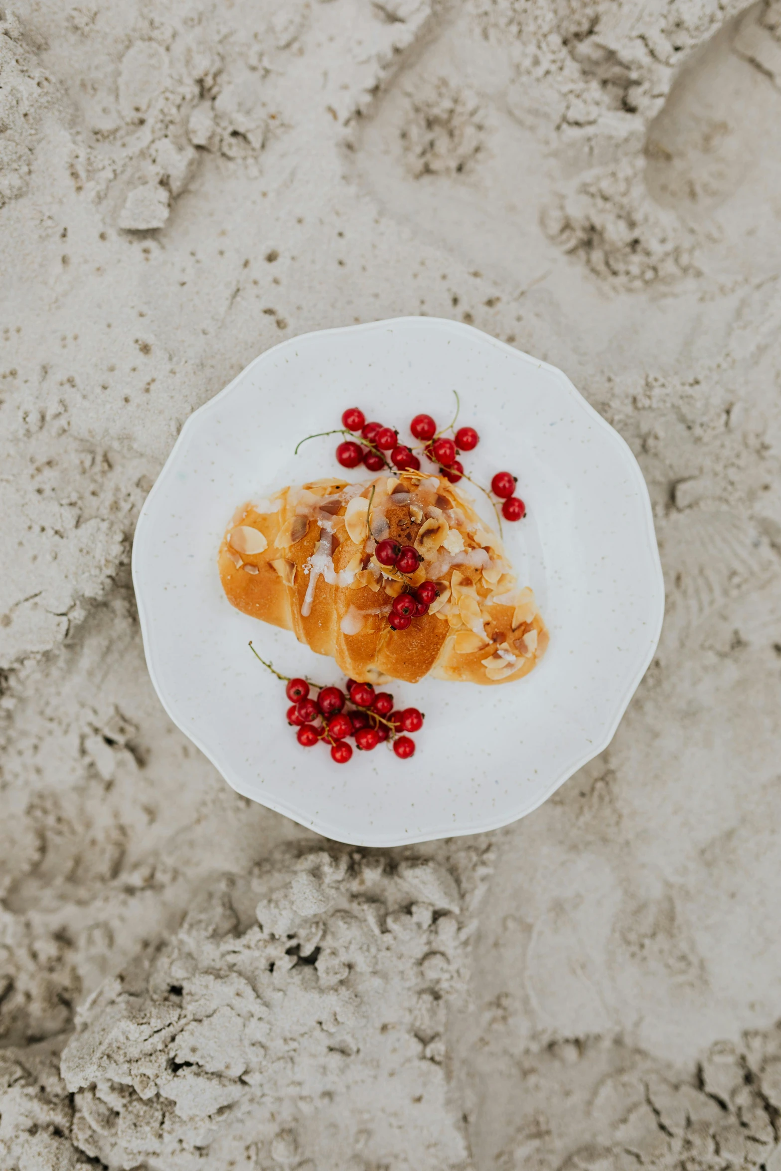 a white plate topped with food on top of a sandy beach, by Emma Andijewska, unsplash, renaissance, with red berries and icicles, caramel, high quality product image”, battered