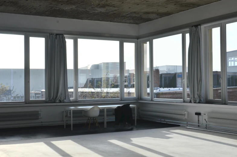 a living room filled with furniture and large windows, inspired by Richard Wilson, unsplash, light and space, an empty brutalist chamber, utrecht, panoramic view, studio mappa