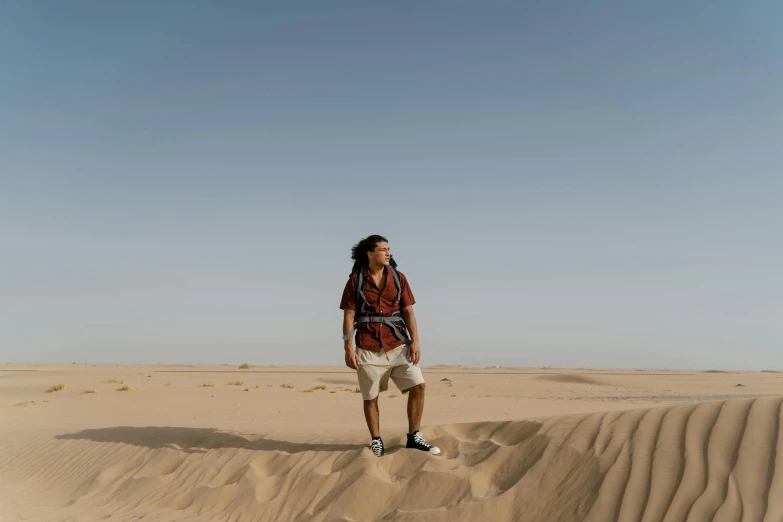 a man standing in the middle of a desert, pexels contest winner, les nabis, avatar image, tanned ameera al taweel, a man wearing a backpack, indigenous man