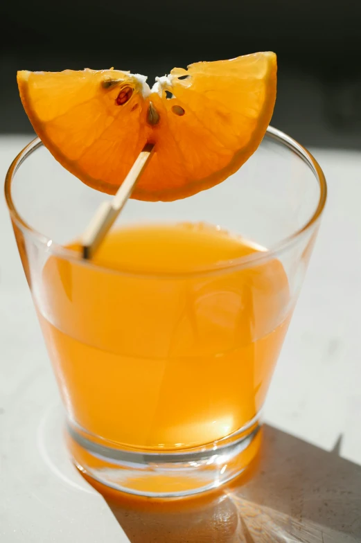 a glass of orange juice with a toothpick sticking out of it, unsplash, renaissance, thumbnail, grey orange, knockout punch, winter sun