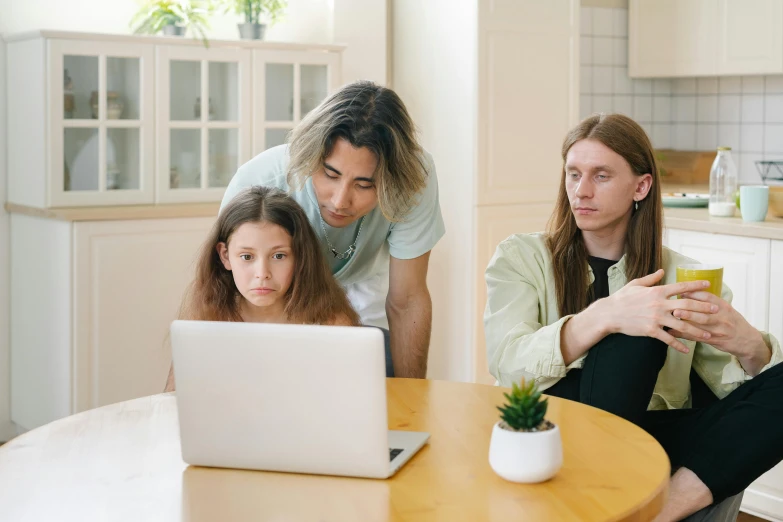 a group of people sitting around a table looking at a laptop, husband wife and son, pokimane, avatar image