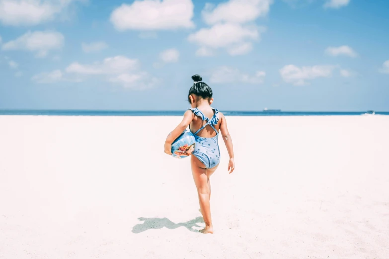 a little girl standing on top of a sandy beach, girl with messy bun hairstyle, monokini, unsplash photo contest winner, playing soccer at the beach