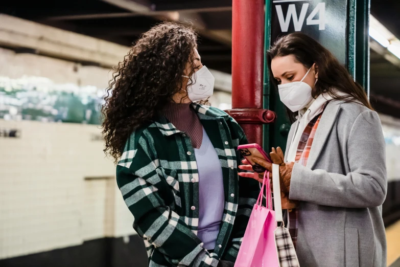 a couple of women standing next to each other on a train platform, trending on pexels, happening, medical mask, giving gifts to people, nyc, avatar image