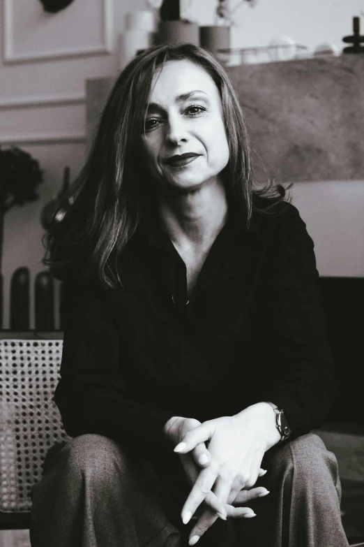 a black and white photo of a woman sitting on a couch, by Marie Courtois, miranda otto, portrait image, low quality photo, promotional image