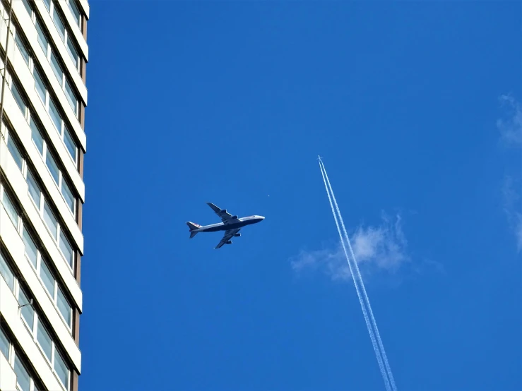 an airplane that is flying in the sky, by Niko Henrichon, hurufiyya, firing it into a building, deep blue sky, in tokio, sighting