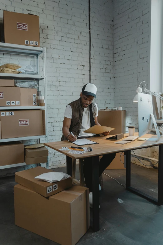 a man sitting at a desk working on a computer, pexels contest winner, arbeitsrat für kunst, delivering packages for amazon, riyahd cassiem, inspect in inventory image, full body image