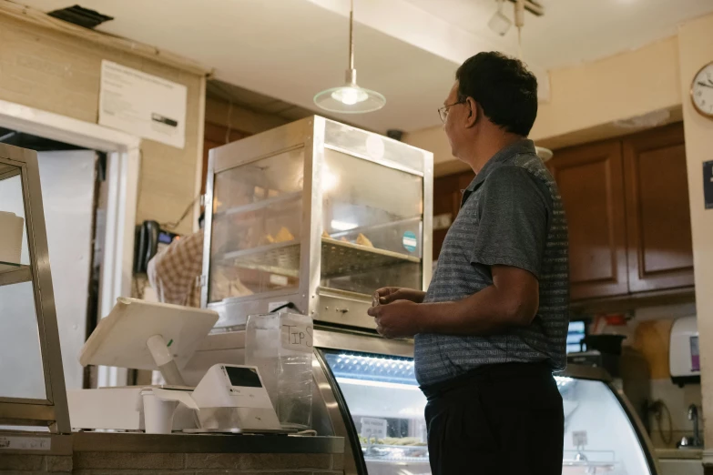 a man that is standing in front of a counter, carrying a tray, profile image, documentary photo, fan favorite