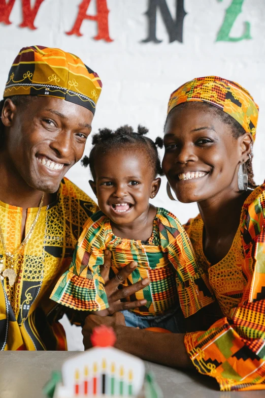 a woman and two children pose for a picture, pexels contest winner, afrofuturism, wearing an african dress, husband wife and son, jamaican colors, happy family