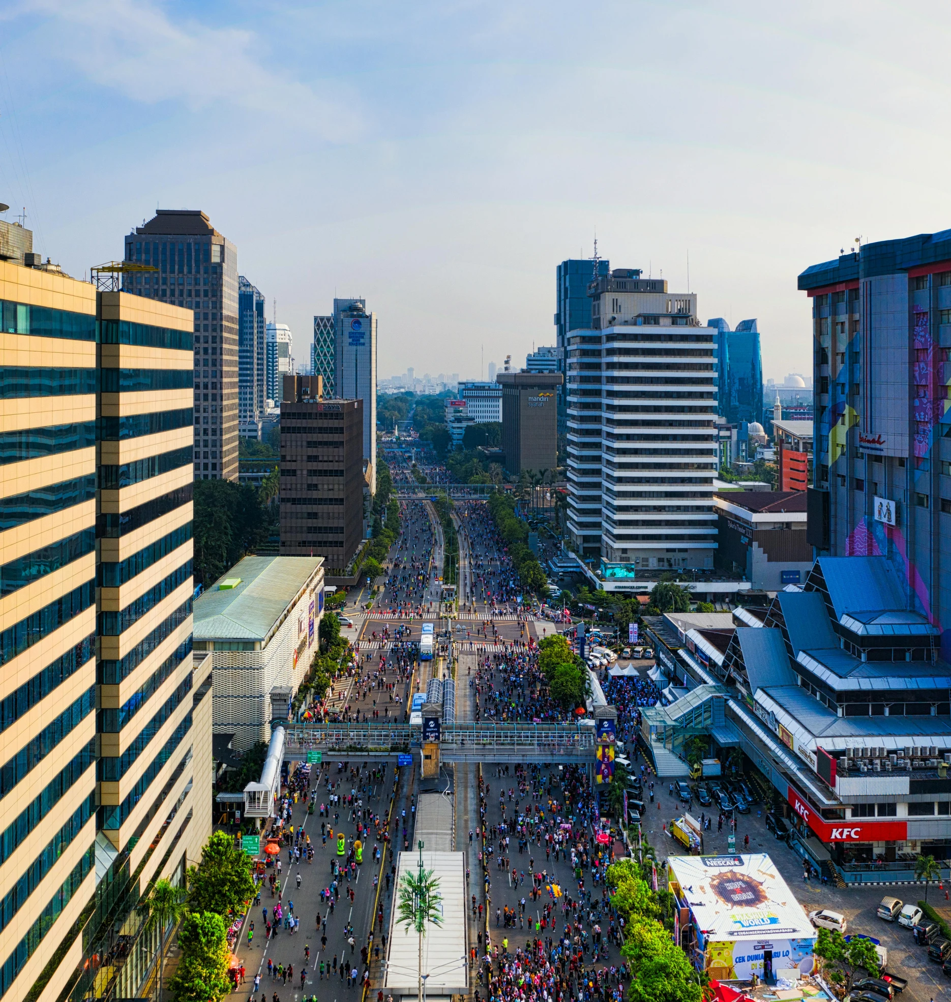 a crowd of people walking down a street next to tall buildings, by Basuki Abdullah, pexels contest winner, hyperrealism, panorama view, marathon race, indonesia, shot from drone