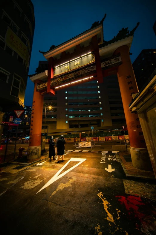 a couple of people that are standing in the street, by Patrick Ching, graffiti, centered torii gate, night life buildings, directions, square