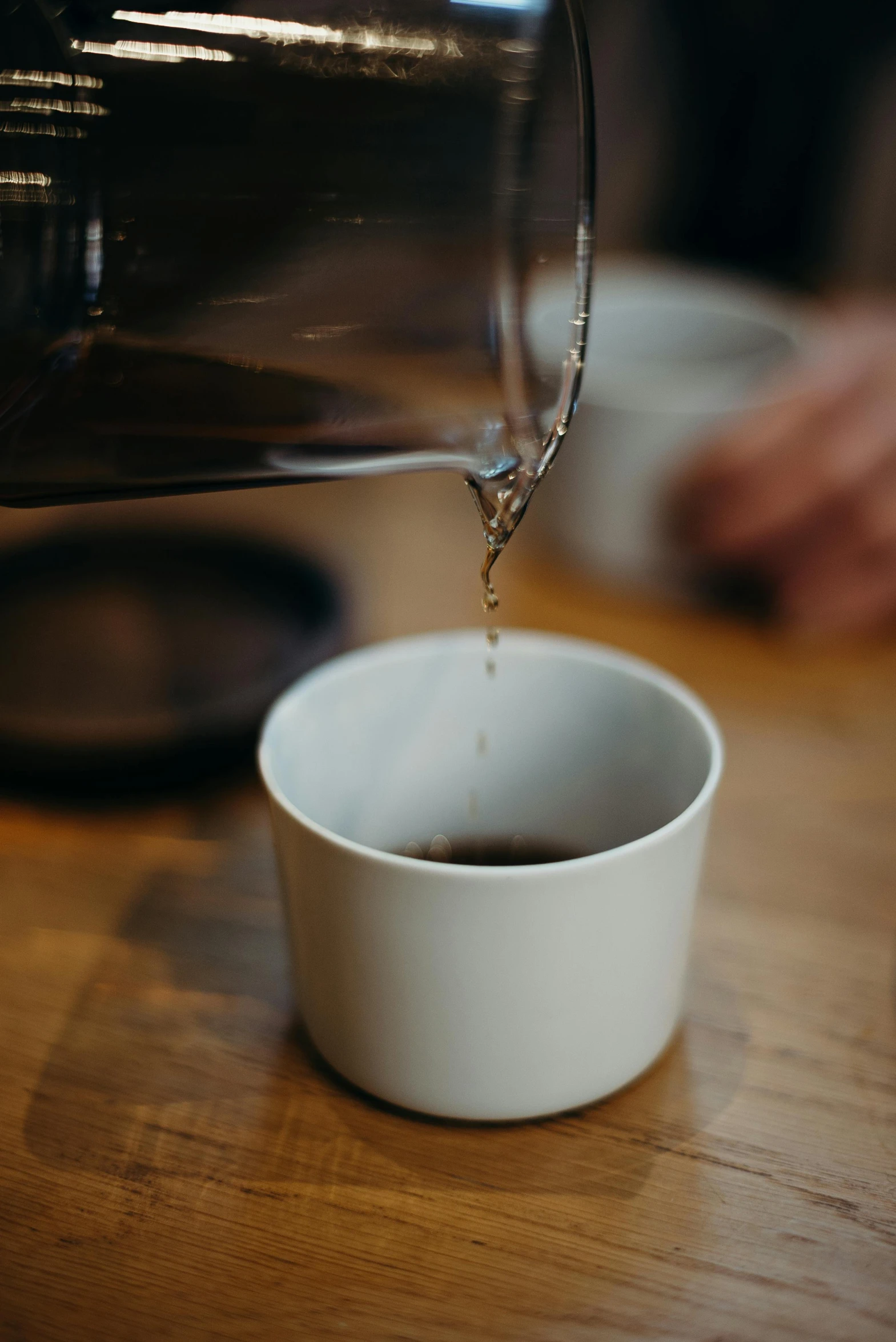 a person pouring a cup of coffee into a cup, by Andrew Domachowski, unsplash, dynamic closeup, made of glazed, blank, maintenance