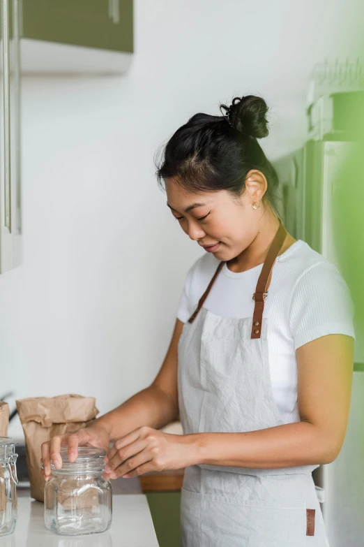 a woman standing in a kitchen preparing food, inspired by Ruth Jên, profile image, single subject, young asian woman, baking cookies