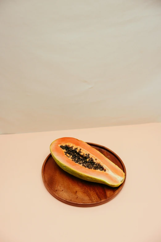 a slice of papana sitting on top of a wooden plate, coral, product image, jen yoon, fruit bowl