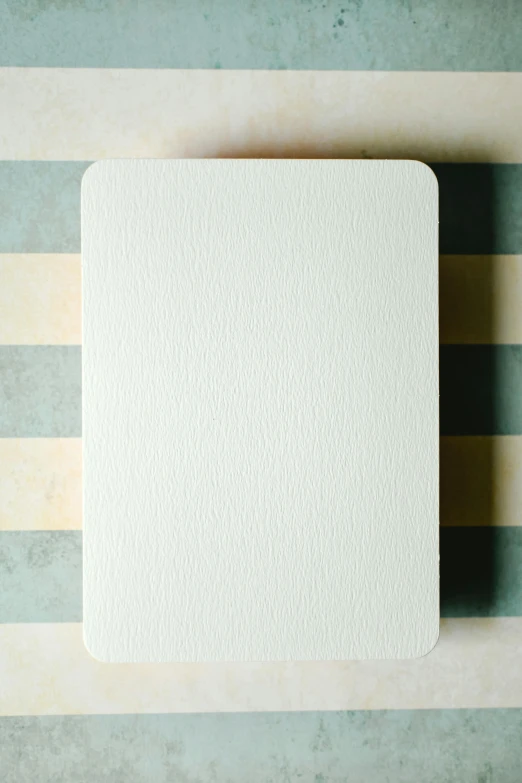 a piece of paper sitting on top of a table, a minimalist painting, inspired by Rachel Whiteread, unsplash, playing card back, very grainy texture, large screen, whole card