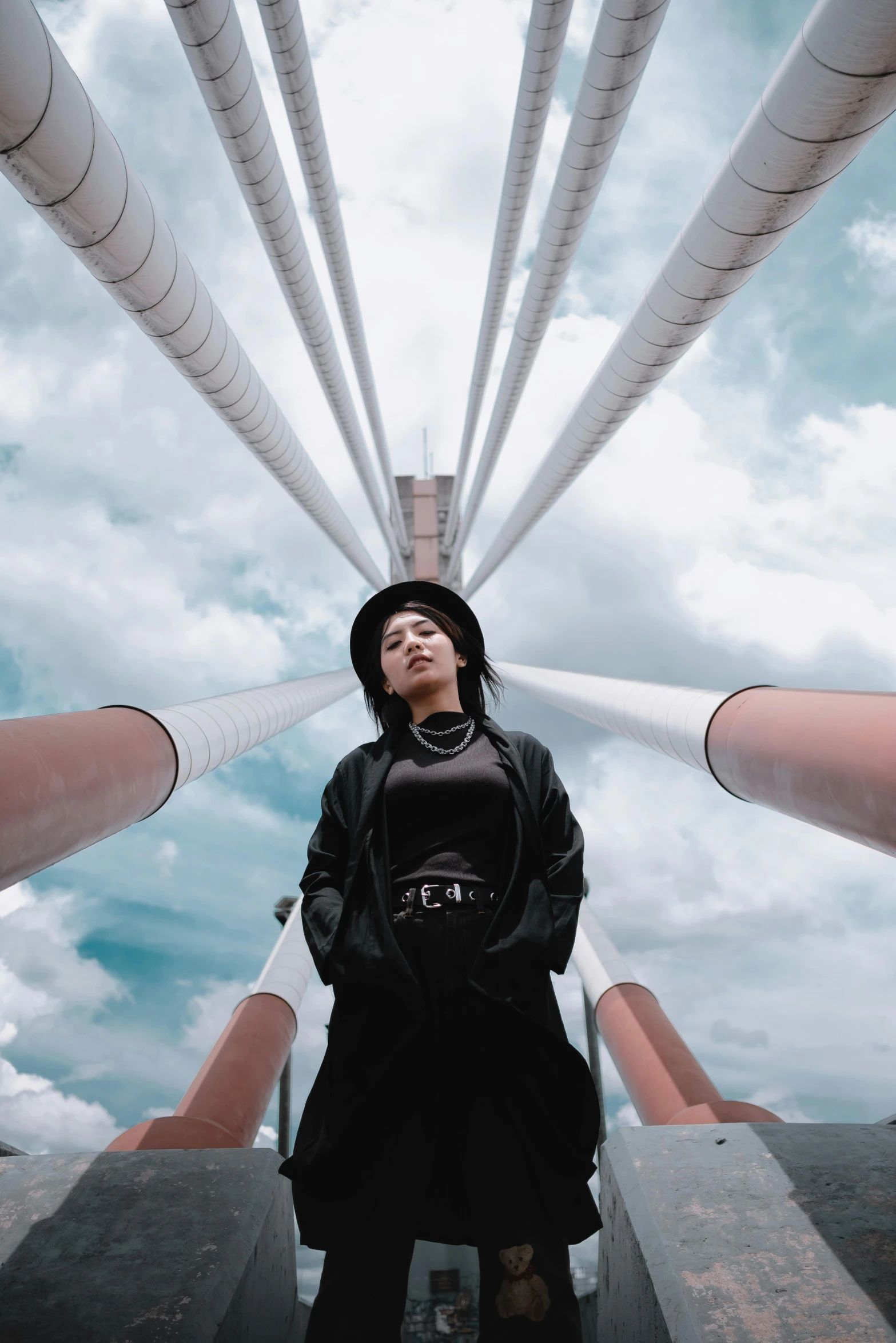 a woman standing in front of a bunch of pipes, inspired by Alexander Rodchenko, pexels contest winner, afrofuturism, pewdiepie selfie at a bridge, sky bridge, standing on the mast, an asian woman