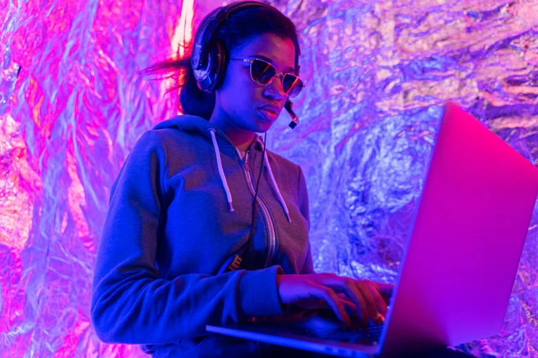 a woman sitting in front of a laptop computer, pexels, holography, dj at a party, from hotline miami, aida muluneh, hunting