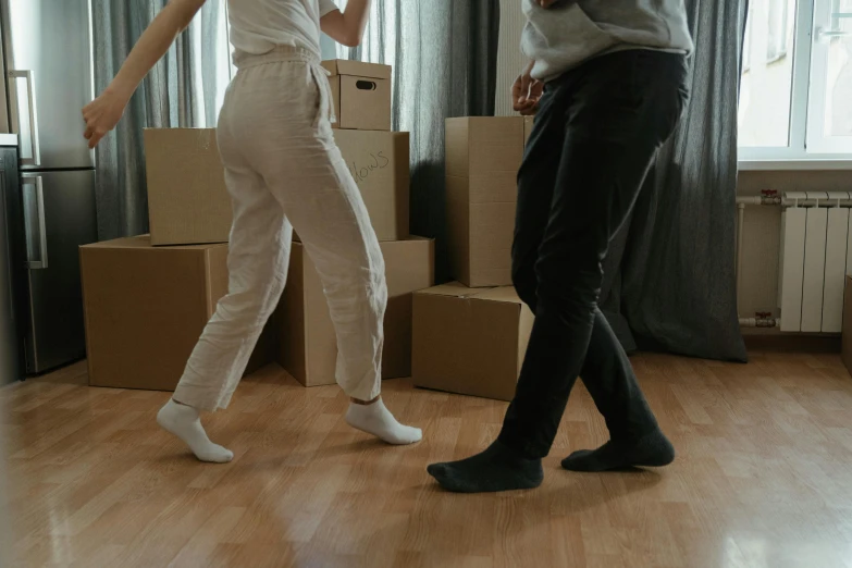 a couple of people standing on top of a hard wood floor, pexels contest winner, happening, dancing character, inspect in inventory image, wearing pants, leaving a room