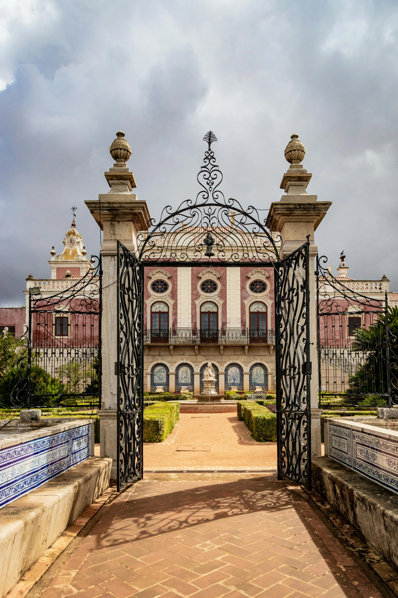 a large building with a fountain in front of it, inspired by Luis Paret y Alcazar, iron gate, neo-classicism, cloud palace, photographed from behind