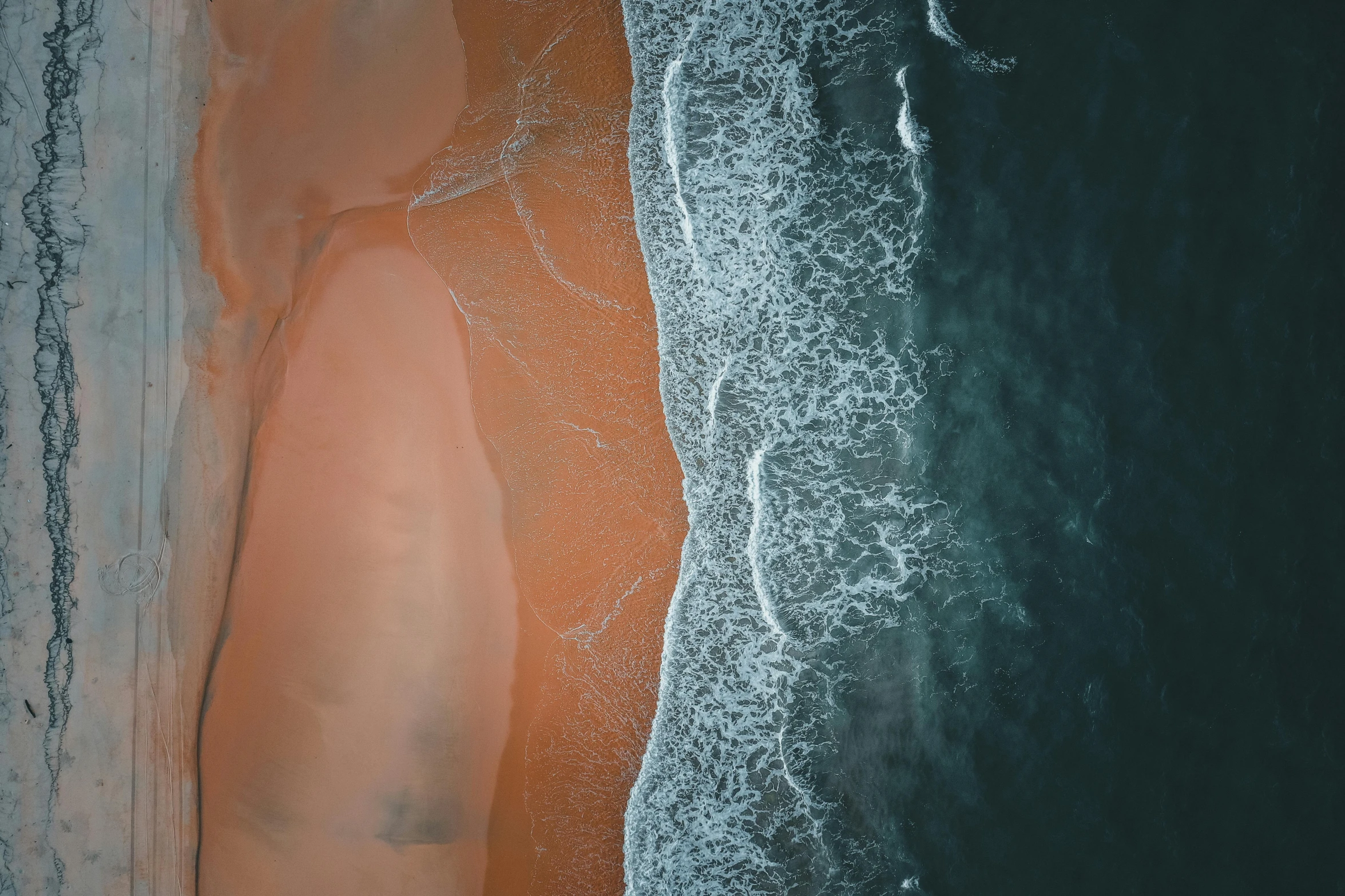 a man standing on top of a sandy beach next to the ocean, by Eglon van der Neer, unsplash contest winner, minimalism, flowing salmon-colored silk, seen from a plane, close together, bottom of ocean