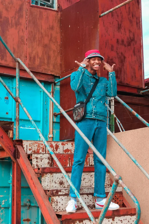 a person standing on a set of stairs, an album cover, trending on pexels, graffiti, teal suit, on ship, baggy clothing and hat, amused