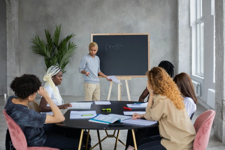 a group of people sitting around a table in a meeting room, a drawing, pexels contest winner, academic art, blackboard, standing in class, in a circle, product introduction photo