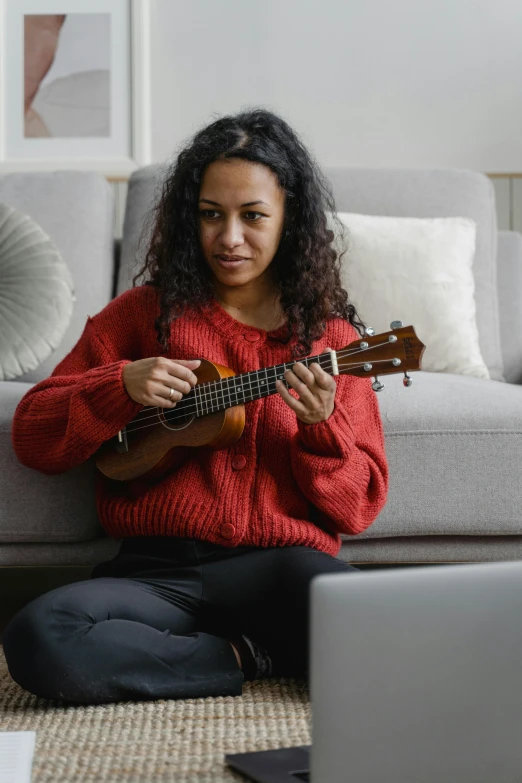 a woman sitting on the floor playing a guitar, wearing a red turtleneck sweater, ukulele, avatar image, sitting on couch