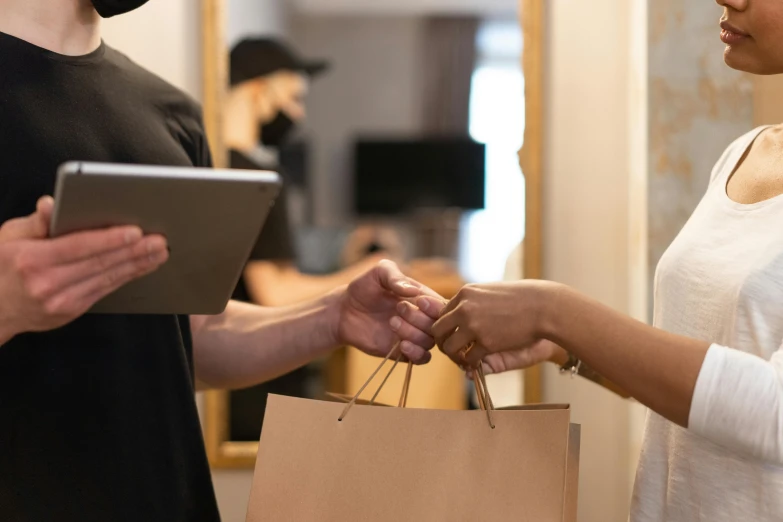 a man standing next to a woman holding a shopping bag, pexels contest winner, renaissance, using a magical tablet, brown paper, zoomed in, healthcare