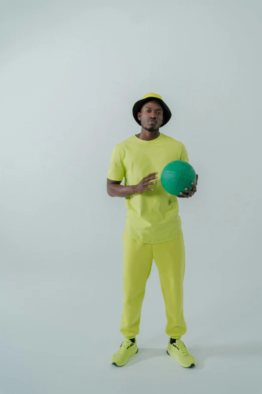 a man in a yellow outfit holding a green ball, inspired by Paul Georges, dribble, bladee from drain gang, commercial shot, ( ( dark skin ) ), surgeon