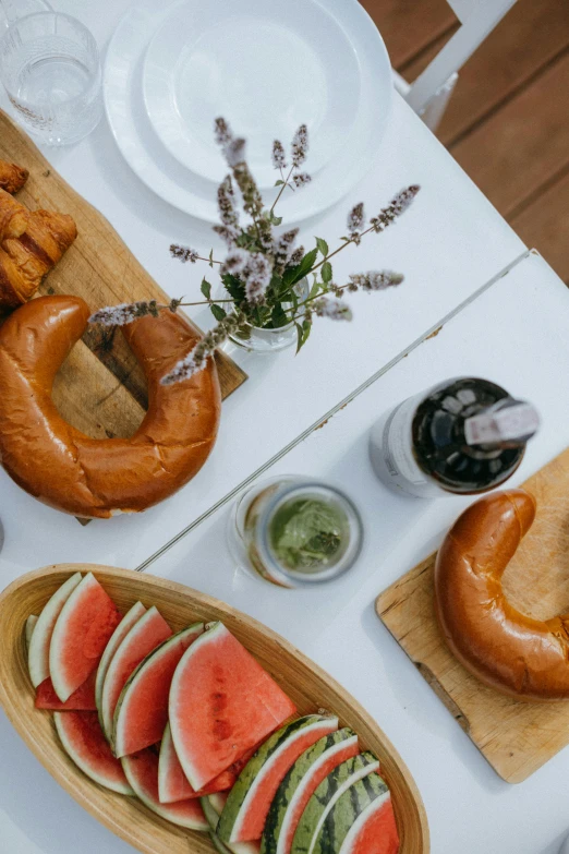 a table that has a bunch of food on it, by Niko Henrichon, trending on unsplash, bagels, midsummer, crisp clean shapes, high quality photo