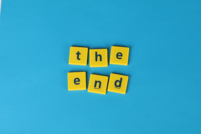 scrabbles spelling the end on a blue background, by Emma Andijewska, trending on unsplash, pop art, ignant, the madness of mono-yellow, taken with sony alpha 9, spare parts