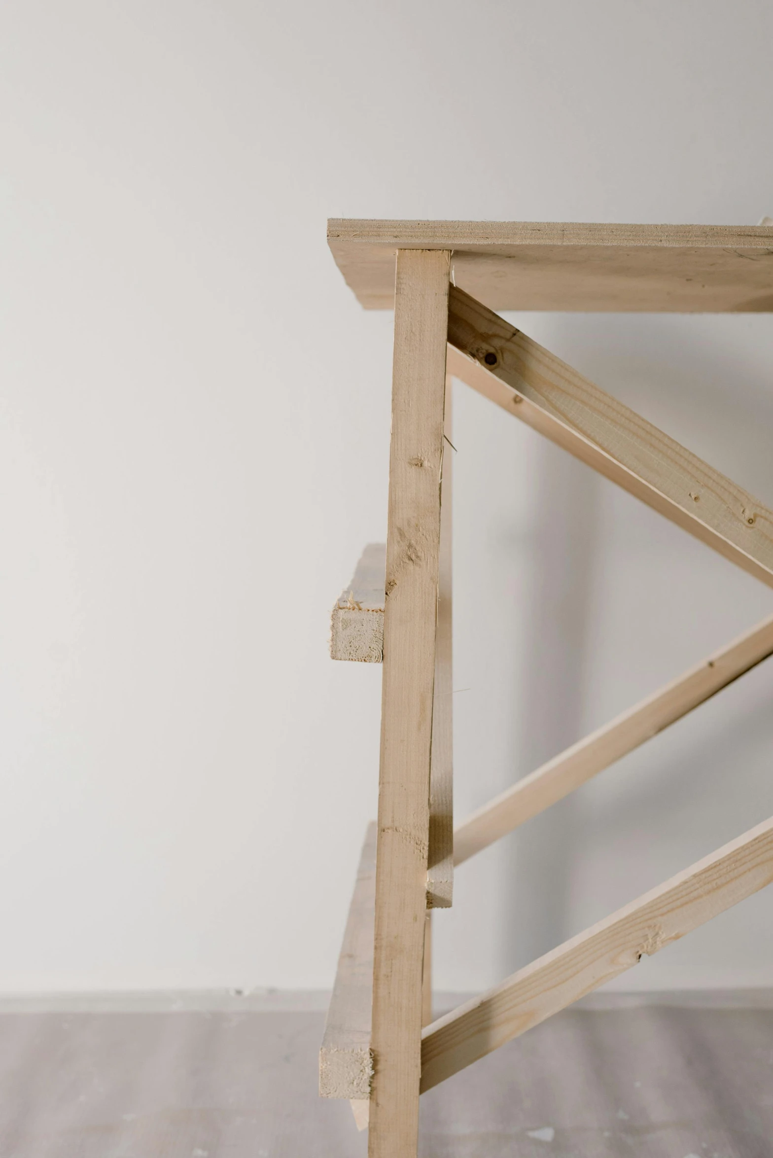 a wooden table sitting on top of a hard wood floor, an abstract sculpture, by Jan Tengnagel, unsplash, conceptual art, ladder, profile close-up view, shelves, scaffolding