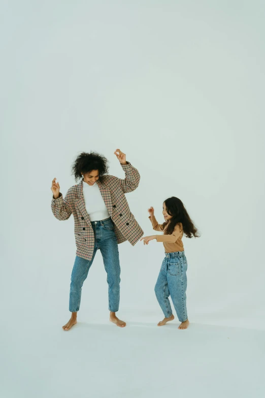 a woman and a little girl dancing in the snow, pexels, denim jeans, on white background, on a checkered floor, - 9