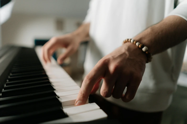 a close up of a person playing a piano, by Carey Morris, trending on pexels, avatar image, white sleeves, casually dressed, on his left hand