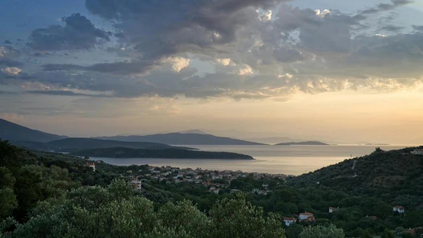a bench sitting on top of a lush green hillside, by Exekias, unsplash contest winner, sunset panorama, bay, view of villages, grey