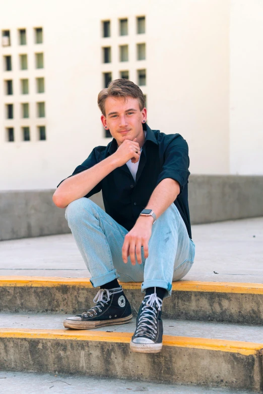 a man sitting on the steps of a building, he looks like tye sheridan, rickroll, lean man with light tan skin, 1990s photograph