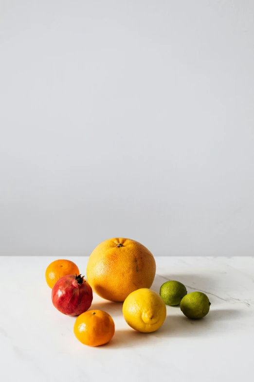 a bunch of fruit sitting on top of a table, by Susan Weil, unsplash, photorealism, plain background, high resolution product photo, standing, grey orange