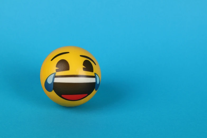 a yellow ball with a smiley face painted on it, a picture, trending on pexels, happening, crying big blue tears, plain background, crying engine, with mouth open