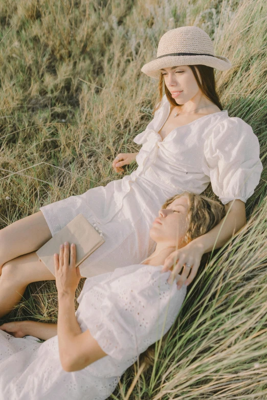 a couple of women laying on top of a grass covered field, by Wen Zhenheng, trending on pexels, renaissance, nico wearing a white dress, puff sleeves, linen, lookbook