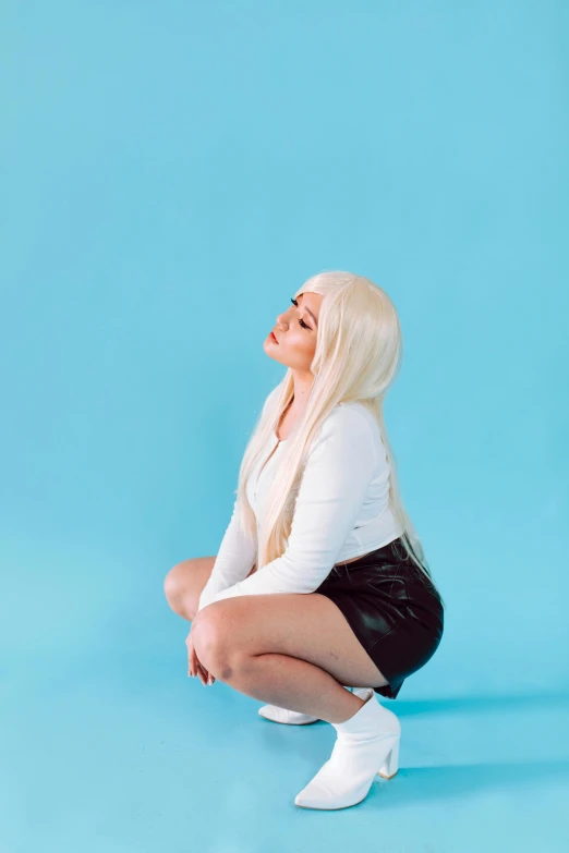 a woman sitting on the ground with her legs crossed, an album cover, inspired by Elsa Bleda, unsplash, white straight hair, kylie jenner, solid background, squatting