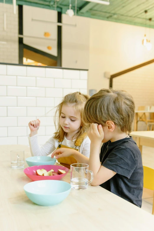 a couple of kids that are sitting at a table, plating, premium quality, trending photo, thumbnail