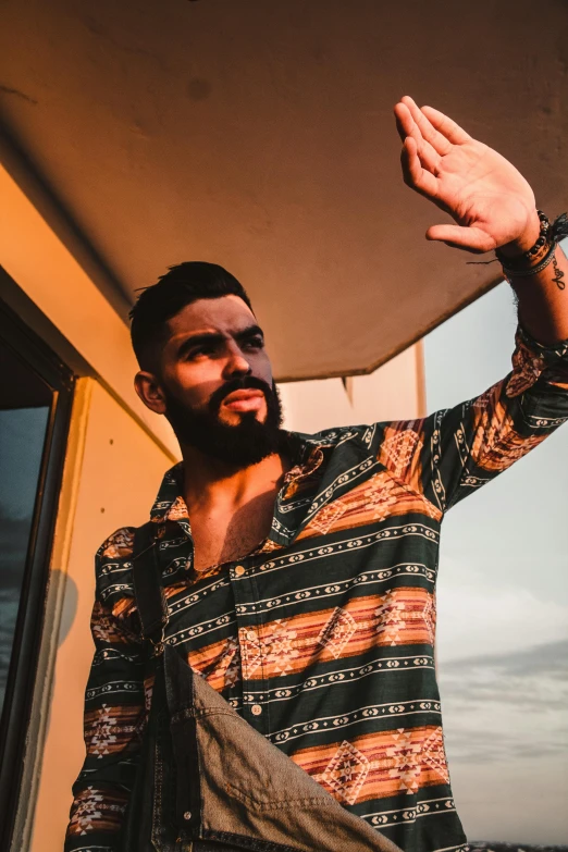 a man standing on top of a boat waving, trending on pexels, renaissance, zayn malik, chest hair, patterned clothing, shot with sony alpha