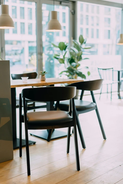 a table and chairs in a room with large windows, a portrait, unsplash, starbucks aprons and visors, thumbnail, armchairs, manuka