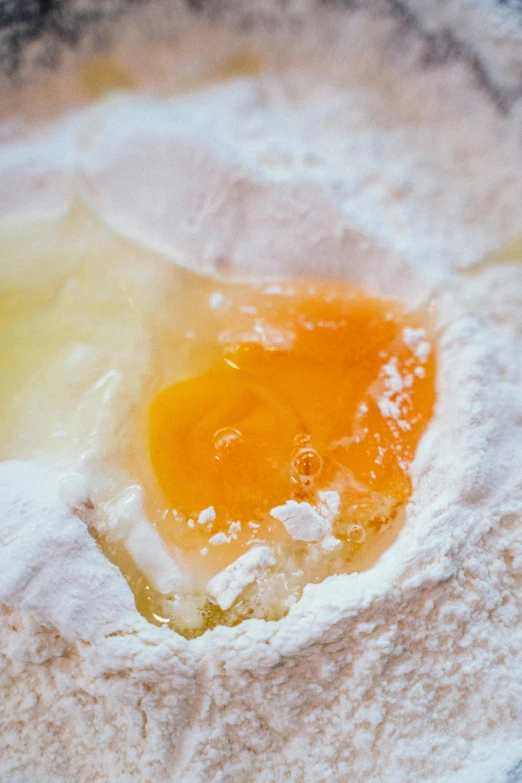 a close up of an egg in a bowl of flour, by Jan Tengnagel, unsplash, marmalade, made of glazed, filling the frame, gooey