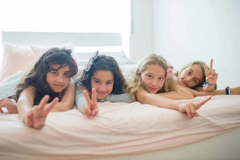 a group of girls laying on top of a bed, kid named finger, gen z, bedhead, premium quality